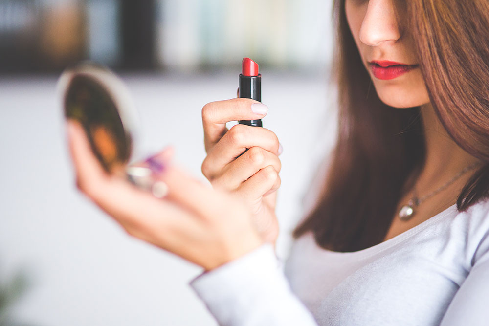 Girl applying lipstick image