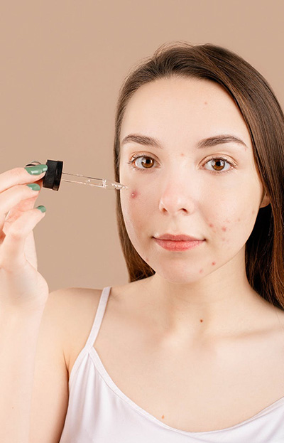 Lady applying facial oil or serum image
